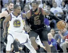  ?? TONY AVELAR/AP ?? Cleveland forward LeBron James dribbles around Golden State’s Kevin Durant during a 99-92 Warriors win on Christmas day.