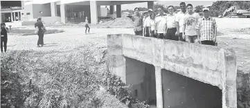  ??  ?? Lo (fourth right) with the project contractor­s and his party members inspecting the site for the drainage system at the junction of Kampung Landeh.