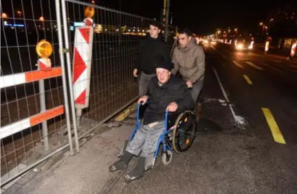  ?? FOTO JAN VAN DER PERRE ?? Dennis en Salim helpen rolstoelge­bruiker Frans even op weg. Maar toch blijft de situatie gevaarlijk. “We zijn ons bewust van de problemen”, klinkt het bij de Noorderlij­n, “maar we kunnen enkel maar aanraden om de veilige omleiding te volgen.”