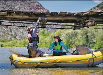  ??  ?? Wendy Meyer of Taos detangles fishing line and hooks from the Glen Woody Bridge as Chrissy Glander of Taos helps stabilize the boat Sunday (June 14) during a trash-collecting trip along the Río Grande.