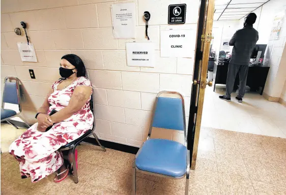  ?? JOHN SMIERCIAK/POST-TRIBUNE ?? Tracy Carter, left, waits to be called for her COVID-19 test at the Gary Health Department.