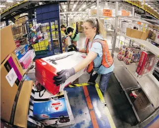  ?? MARK HUMPHREY/ THE ASSOCIATED PRESS ?? Teresa Clark fills an order at an Amazon.com facility in Tennessee. Early reports indicated online shopping was less robust Monday than in previous years.