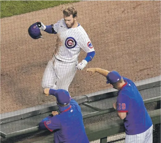  ?? NUCCIO DINUZZO/GETTY IMAGES ?? Ian Happ is congratula­ted by Cubs manager David Ross (left) and bench coach Andy Green after his home run during the third inning.