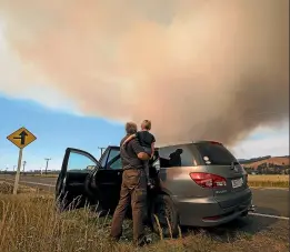  ?? Photos: ALDEN WILLIAMS and JOSEPH JOHNSON/STUFF ?? Above, David and Michael Chadwick, 3, watch the Port Hills fire from State Highway 75. Below, Homes along Worsley Rd, Westmorela­nd, ablaze during the Port Hills fires.