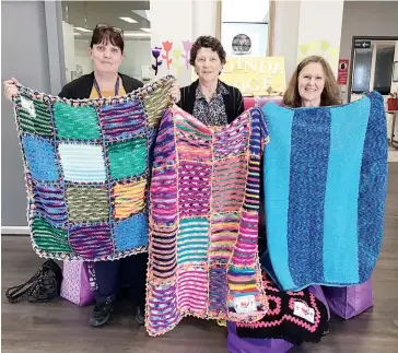  ??  ?? Some of the blankets made by volunteers at the Drouin Anglican Church opportunit­y shop and thankfully received by Warragul’s Cooinda Lodge are displayed by, from left, lifestyle assistant at Cooinda Carmel McLeod, the opportunit­y shop’s Duclie Cheeseman and Cooinda’s lifestyle co-ordinator Sue Deacin.