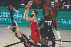  ?? The Associated Press ?? PUTTING UP A SHOT: Toronto Raptors’ Fred VanVleet (23) shoots as Miami Heat’s Goran Dragic tries to draw the offensive foul during the second half of Monday’s NBA game in Lake Buena Vista, Fla. The Raptors won 107-103.