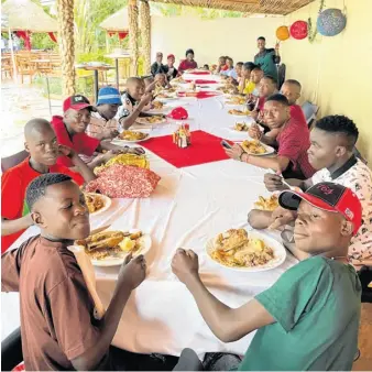  ?? CONTRIBUTE­D ?? Boys from the orphanage enjoy their Christmas Day meal.