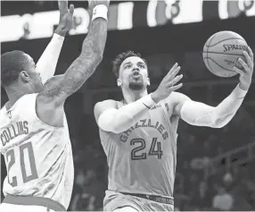  ?? JOHN AMIS/AP ?? Grizzlies guard Dillon Brooks (24) shoots as Hawks forward John Collins defends during the first half of Monday’s game in Atlanta.