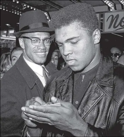  ?? AP PHOTO ?? In this March 1, 1964, file photo, world heavyweigh­t boxing champion, Muhammad Ali, right, is shown with Black Muslim Leader, Malcolm X, outside the Trans-lux Newsreel Theater on Broadway at 49th Street in New York City. They had just watched a...