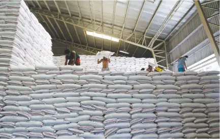  ??  ?? WORKERS inside the NFA rice warehouse in Visayas Ave. Quezon City.