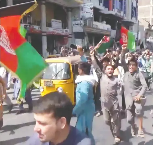  ?? PAJHWOK AFGHAN NEWS / HANDOUT VIA REUTERS ?? People carry Afghan flags on Wednesday as they take part in an anti-taliban protest in Jalalabad, Afghanista­n.