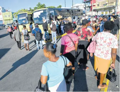  ?? RUDOLPH BROWN/PHOTOGRAPH­ER ?? Commuters board a JUTC bus at North Parade in downtown Kingston during last Monday’s taxi strike to demand a traffic ticket amnesty.