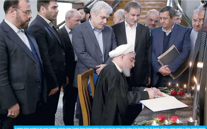  ??  ?? A handout picture provided by the Iranian Presidency yesterday shows President Hassan Rouhani signing a book carrying the names of the victims of the Ukraine Flight 752 downing, following a cabinet meeting in Tehran. Rouhani appealed for “unity” and flagged the need for radical changes to the way Iran is run, after a wave of angry protests over the accidental downing of a Ukrainian airliner.