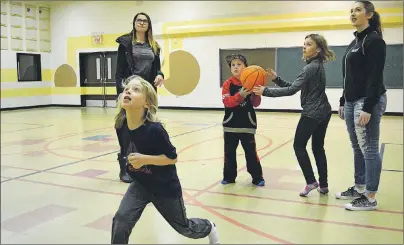  ??  ?? Brady Day watches intently after shooting a basketball at the hoop during the Southend Community Centre after-school program Tuesday. Looking on are after-school worker Mikayla MacDonald, from left, Ty MacDonald, Anna Lawand and after-school worker...