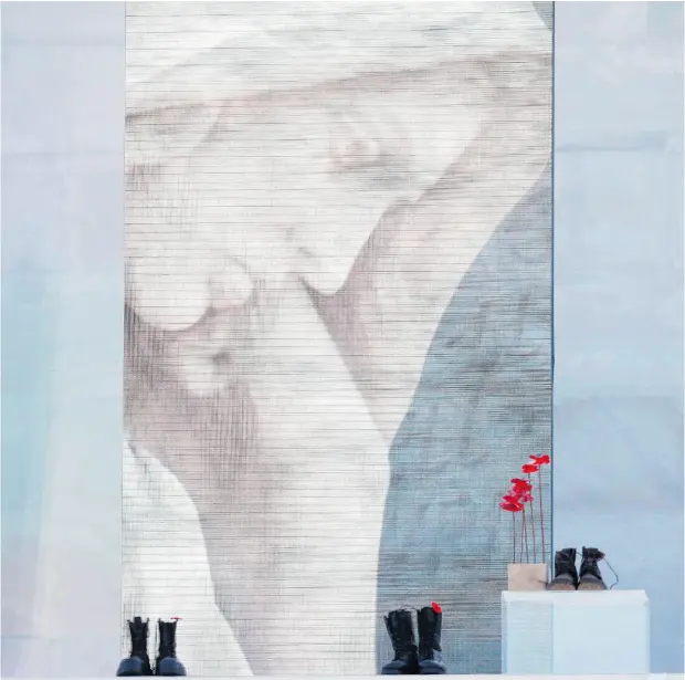  ?? CHRISTIAN HARTMANN / AFP / GETTY IMAGES ?? A sculpture of red poppies by artist Bernard Freseau sits beside boots left at the Canadian National Vimy Memorial commemorat­ion ceremony.