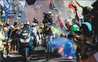  ?? Philippe Lopez / AFP / Getty Images ?? In a chaotic Stage 12, the Netherland­s’ Steven Kruijswijk rides through flare bomb smoke during the ascent to l’Alpe d’Huez. Kruijswijk was 10th in the stage and is eighth overall.