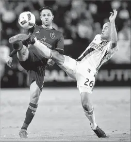  ?? Alex Gallardo Associated Press ?? THE GALAXY’S Landon Donovan, right, battles for the ball with Real Salt Lake’s Juan Martinez in the first half. The Galaxy won the eliminatio­n game, 3-1.