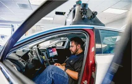  ?? Santiago Mejia / San Francisco Chronicle ?? Martin Vega checks the software of the self-driving vehicle at Drive.ai, a Silicon Valley startup that was recently acquired by Apple. But the iPhone-maker has been otherwise mum on the topic.