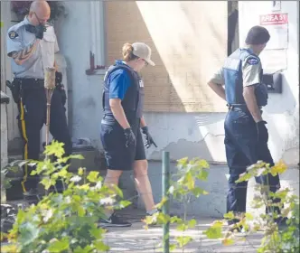  ?? Herald file photo ?? City bylaw services manager Tina Siebert (middle) gestures to something during an August visit to a nuisance property on Winnipeg Street.