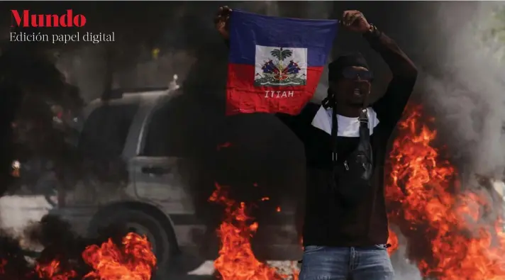  ?? ?? ►Un joven sostiene una bandera haitiana durante una protesta contra el primer ministro Ariel Henry.