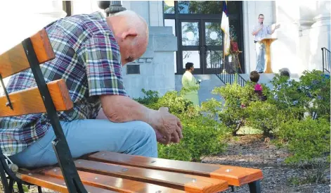  ?? STAFF PHOTO BY TIM BARBER ?? Jerry Fratantuon­o sits outside the Hamilton County Courthouse during a prayer offered by Adam Whitescarv­er, far right, executive director of the Chattanoog­a House of Prayer, as part of a prayer gathering Sunday afternoon on the anniversar­y of the Sept....