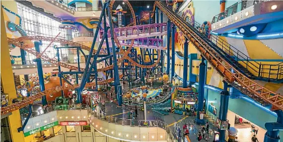  ?? BROOK SABIN ?? The roller coaster at Berjaya Times Square comes within centimetre­s of shoppers at the mall.