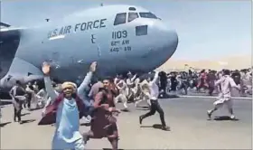  ?? Photos: Defence One, Eyepress NEWS/AFP & Hoshang Hashimi/afp ?? Fearful: Afghans (above left) fill a US Air Force transport aircraft flying to Qatar. A screen grab (above) from a video shows Afghans wanting to board an aircraft taxiing for take-off. Taliban fighters (left) move around Kabul.