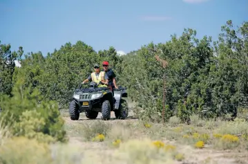  ?? LUIS SÁNCHEZ SATURNO/THE NEW MEXICAN ?? Eric Martinez, front, and Albert Rodriguez of Española, use their ATV on Tuesday to help in the search near Española for Renezmae Calzada, a 5-year-old girl who went missing Sunday morning.