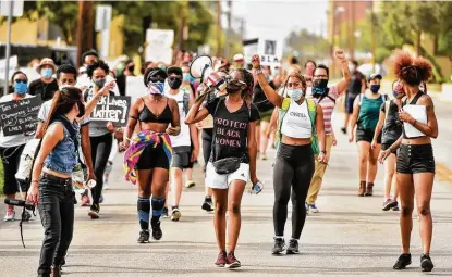  ??  ?? Sodonya Dalton leads chants as marchers walk along Hackberry Street during the Young Ambitious Activists’ Women Against Injustice march on Saturday. Demonstrat­ors walked from the Carver Cultural Community Center to Pitman Sullivan Park.
Photos by Robin Jerstad / Contributo­r