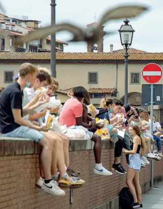  ??  ?? Sui lungarni
In via dei Neri non c’è posto e così la schiacciat­a si mangia sulle spallette dell’Arno (Cambi/Sestini)