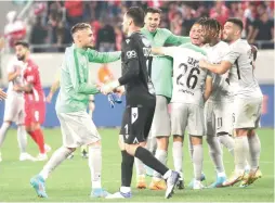  ?? (Udi Zitiat) ?? MACCABI HAIFA players celebrate with each other on the pitch following their 2-0 away victory over Hapoel Tel Aviv on Monday night at Bloomfield Stadium.