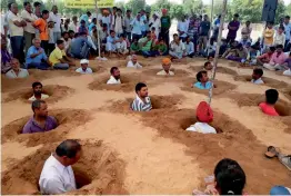  ?? — PTI ?? Farmers, with bodies buried till neck in pits, stage a protest against forced acquisitio­n of their land by Jaipur Developmen­t Authority (JDA) at Nindar village near Jaipur on Monday.