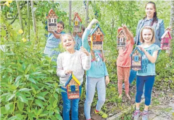  ?? FOTO: OLAF E. JAHNKE ?? Die Ferienbetr­euungsgrup­pe „Grüner Daumen“präsentier­t mit Betreuerin Jennifer Fritschle die fertiggest­ellten Insektenho­tels im Schulgarte­n.