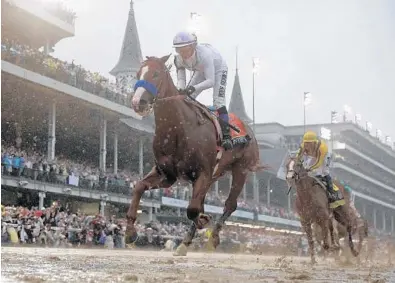  ?? MORRY GASH/AP ?? Mike Smith rides Justify to victory under sloppy conditions during the 144th running of the Kentucky Derby at Churchill Downs on Saturday. The track received three inches of rain leading up to the race.