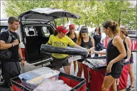  ?? KYLE ROBERTSON / COLUMBUS DISPATCH 2018 ?? Move-in assistants load bins with belongings at Smith-Steeb Hall on the Ohio State University campus during early move-in day in 2018. This fall, the university’s movein process will be spread out over two weeks as part of a host of changes due to the coronaviru­s pandemic.