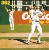  ?? RAY CHAVEZ — BAY AREA NEWS GROUP ?? Jason Isringhaus­en celebrates after Oakland defeated Texas to win the AL West championsh­ip in October 2000.