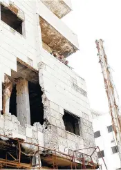  ??  ?? Syrian soldiers look out from a damaged building in Daraya, a blockaded Damascus suburb, on Friday.