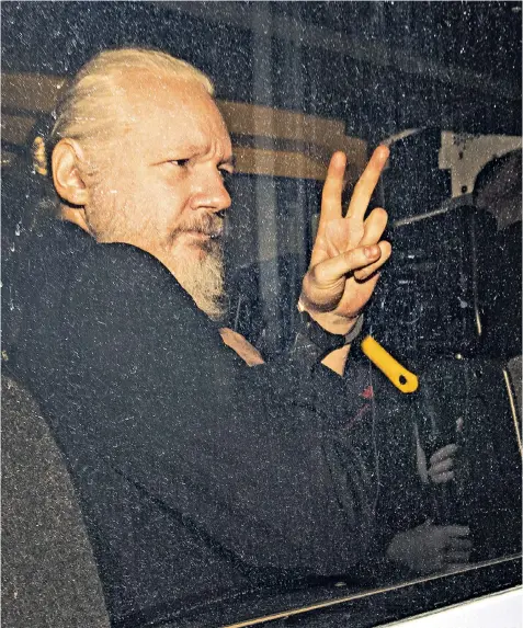  ??  ?? A defiant Julian Assange arrives in a police van at court, where he faced a charge of failing to surrender to bail, as well as a US bid to extradite him over the release of classified documents