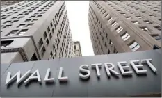  ?? AP Photo/Mark Lennihan ?? Buildings line Wall Street, Monday, in New York.
