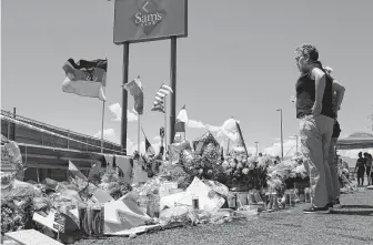  ?? Cedar Attanasio / Associated Press ?? Flowers, crosses and handwritte­n messages now adorn a makeshift memorial outside one of Walmart’s entrances. The company plans to rebuild the interior following the massacre on Aug. 3.