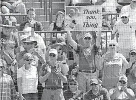  ?? [PHOTO BY SARAH PHIPPS, THE OKLAHOMAN] ?? Oklahoma softball fan Mike Kertok, 58, of Norman, holds one of his many signs in support of the Sooners over the weekend at Marita Hynes Field in Norman. He has been attending games since 1999.