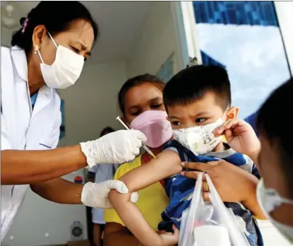  ?? TANG CHHIN SOTHY / AFP ?? A boy receives a COVID-19 vaccine from China’s Sinovac Biotech at a health center in Phnom Penh, Cambodia, on Feb 24 last year.