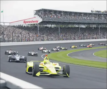  ?? DARRON CUMMINGS — THE ASSOCIATED PRESS ?? Simon Pagenaud leads the field through the first turn on the start of the 2019 Indianapol­is 500 at Indianapol­is Motor Speedway.
