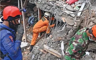  ?? (AFP) ?? Rescuers search for survivors at a collapsed building in Mamuju city on January 16, 2021, a day after a 6.2-magnitude earthquake rocked Indonesia's Sulawesi island