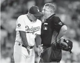  ?? JOHN MCCOY GETTY IMAGES ?? Dodgers manager Dave Roberts argues with umpire Greg Gibson last season. Under new rules, managers now will have 20, not 30 seconds to challenge a play.