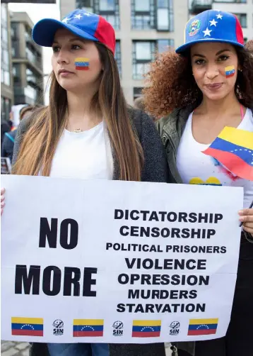  ??  ?? WORDS OF WARNING: Venezuelan protesters Leidy Corredor and Dorielis Perez holding a placard denouncing President Nicolas Maduro at a rally held in the Smithfield area of Dublin last week