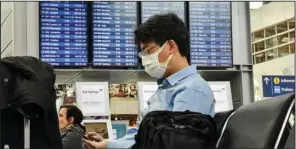  ?? (AP/Martin Meissner) ?? A passenger with a mask waits for his flight at the airport in Dusseldorf, Germany, in March 2020. The European Union Aviation Safety Agency said Wednesday that from next week onward it is no longer recommendi­ng the use of medical masks at airports and on planes due to the coronaviru­s.