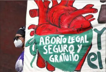  ?? Rebecca Blackwell/Associated Press ?? A woman holds a banner reading in Spanish, “Legal, safe, and free abortion” in September 2020 in Mexico City. Mexico’s Supreme Court on Wednesday decriminal­ized abortion nationwide.