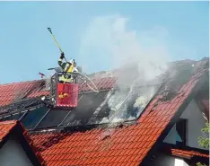  ?? Foto: Benjamin Reif ?? Die Feuerwehr schlug die Solareleme­nte und Dachziegel mit Stangen vom Dach ab, um gezielt löschen zu können.