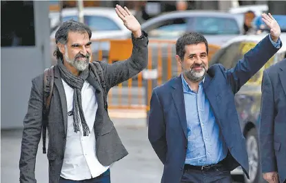  ?? GABRIEL BOUYS/AFP ?? Jordi Cuixart y Jordi Sánchez saludan a su llegada a la Audiencia Nacional ayer en Madrid.